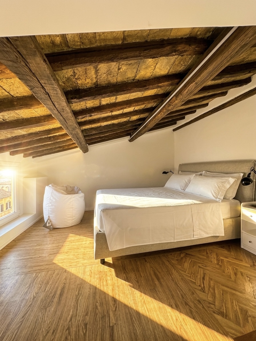 Camera da letto in mansarda con travi in legno a vista